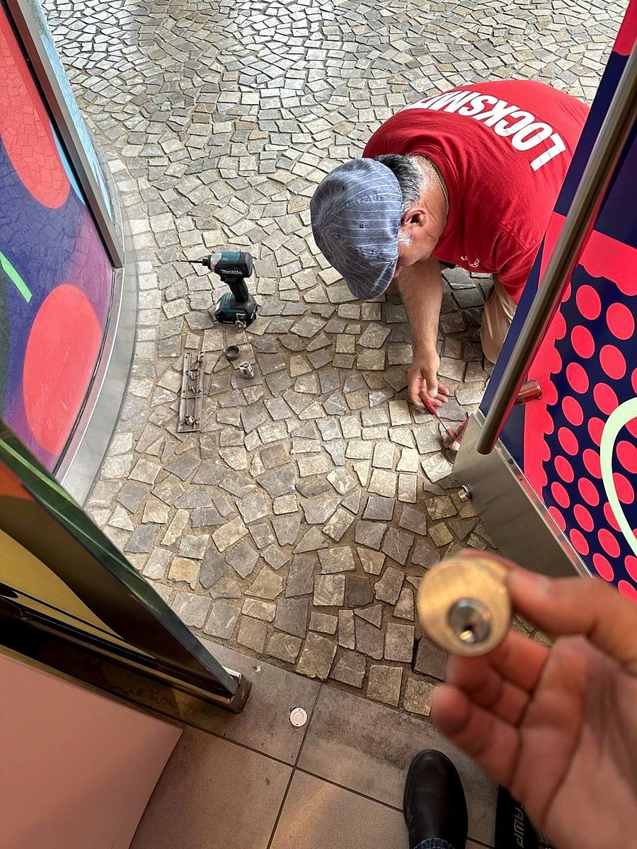 A Silver State Locksmith technician holds a fresh mortise cylinder at a storefront door on the Las Vegas Strip