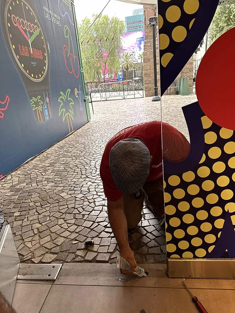 Technician setting a floor lock at a glass storefront door